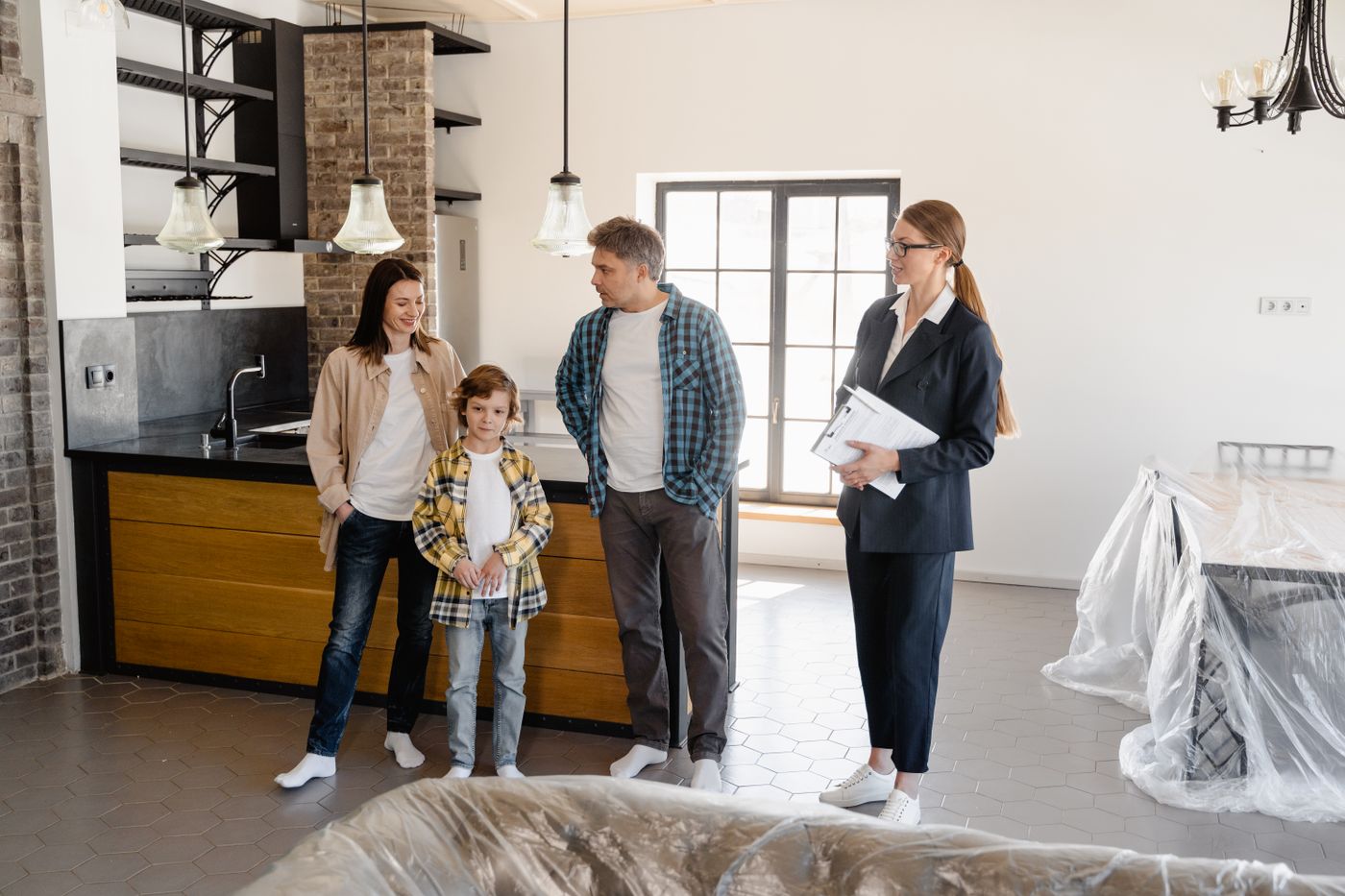 A family touring the kitchen of a home with an agent