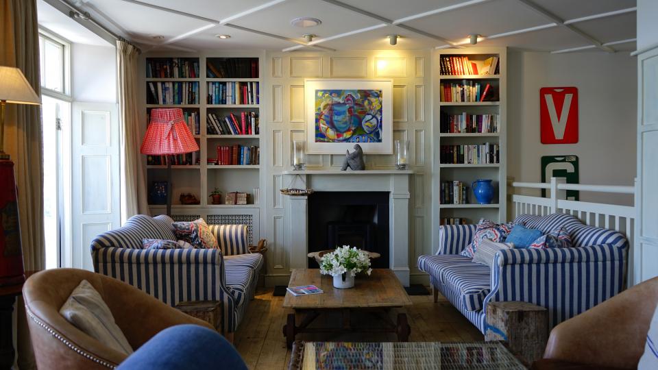 A shared living room with several sofas and armchairs around a fireplace